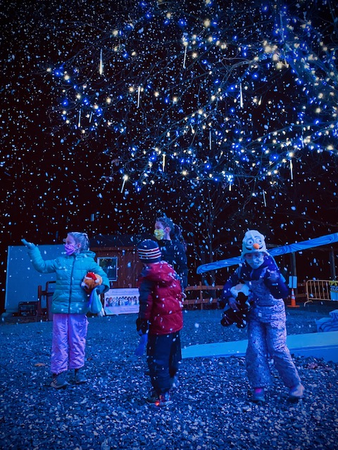 Children dancing under artificial snow near the princess performance stage at Winter Light Spectacular