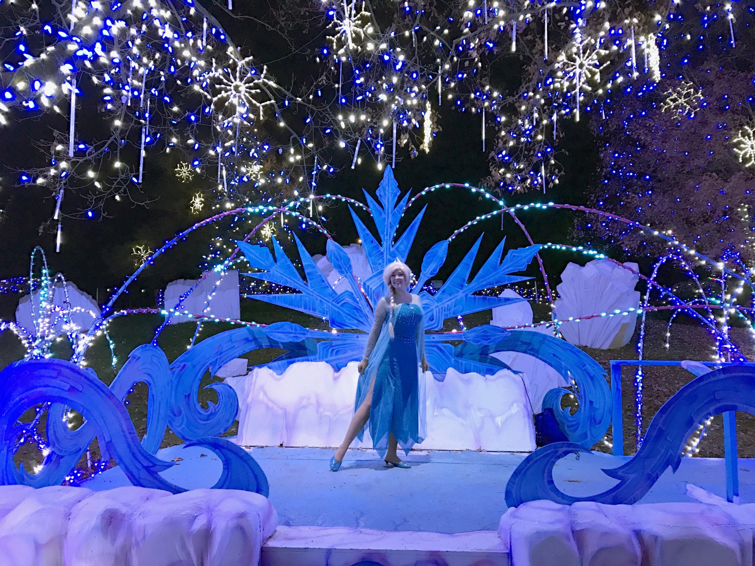 Elsa on the princess performance stage, adorned with ice motifs and blue holiday lights