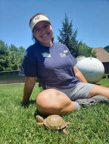 Conservation Education intern Jessie posing with a turtle