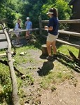 A conservation education intern doing an animal mingle presentation in front of zoo guests