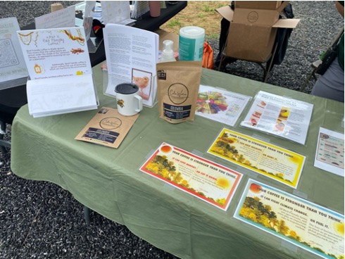 A table featuring Bird Friendly coffee available for purchase along with flyers and infographics about the importance of shade grown coffee