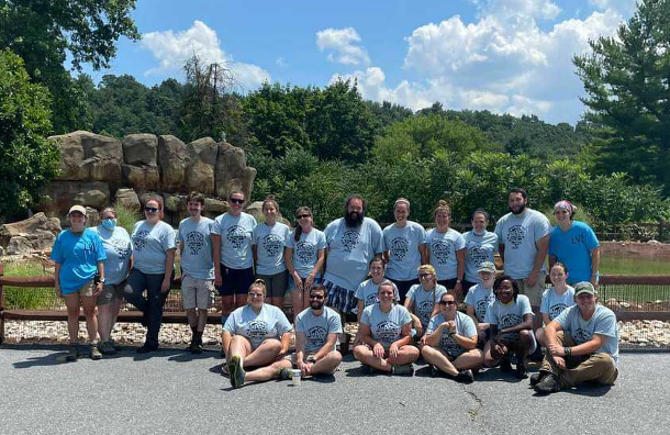 23 of the Lehigh Valley Zoo's animal care and education staff posing for a group photo in front of the zoo's African Penguin exhibit