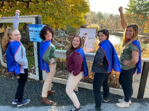 Photo of Zoo Educators wearing superhero capes (left to right): Tara, Cher, Dani, Emily, and Natalie