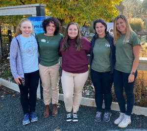 Photo of Lehigh Valley Zoo conservation educators posing in front of our African Penguin exhibit. From left to right: Tara, Cher, Dani, Emily, Natalie