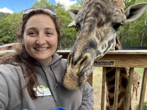 Photo of conservation educator Dani with a Masai giraffe