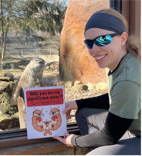 Education specialist Tara presenting a Valentine's Day card to Luani the river otter
